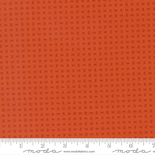 Orange fabric with a subtle pattern and a ruler at the bottom for scale.