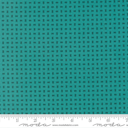 Teal fabric with a small checkered pattern and a ruler at the bottom for scale.