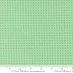 Green fabric pattern with a ruler for scale on a green background