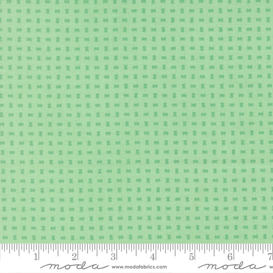 Green fabric pattern with a ruler for scale on a green background