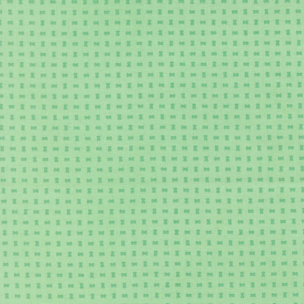 Green patterned background with small spool design