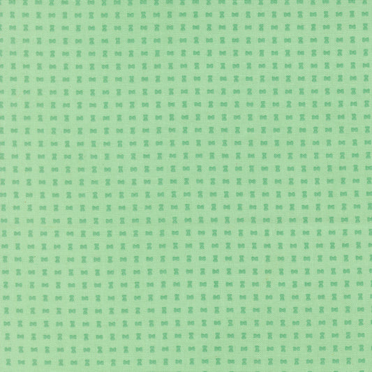 Green patterned background with small spool design