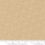 Fabric with small polka dots on a beige background, featuring a ruler at the bottom for scale.