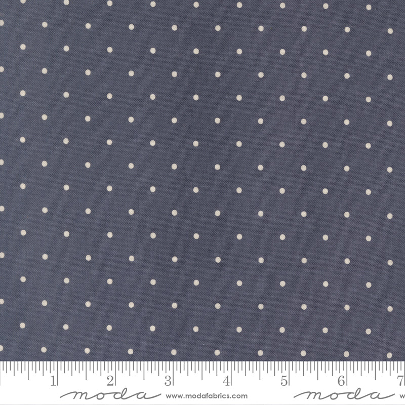 Navy blue fabric with small white polka dots and a ruler at the bottom