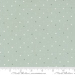 Fabric swatch with small polka dots on a light gray background, featuring a ruler for scale