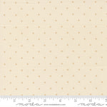 Fabric with small polka dots on a beige background, featuring a ruler for scale