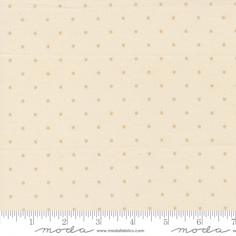 Fabric with small polka dots on a beige background, featuring a ruler for scale