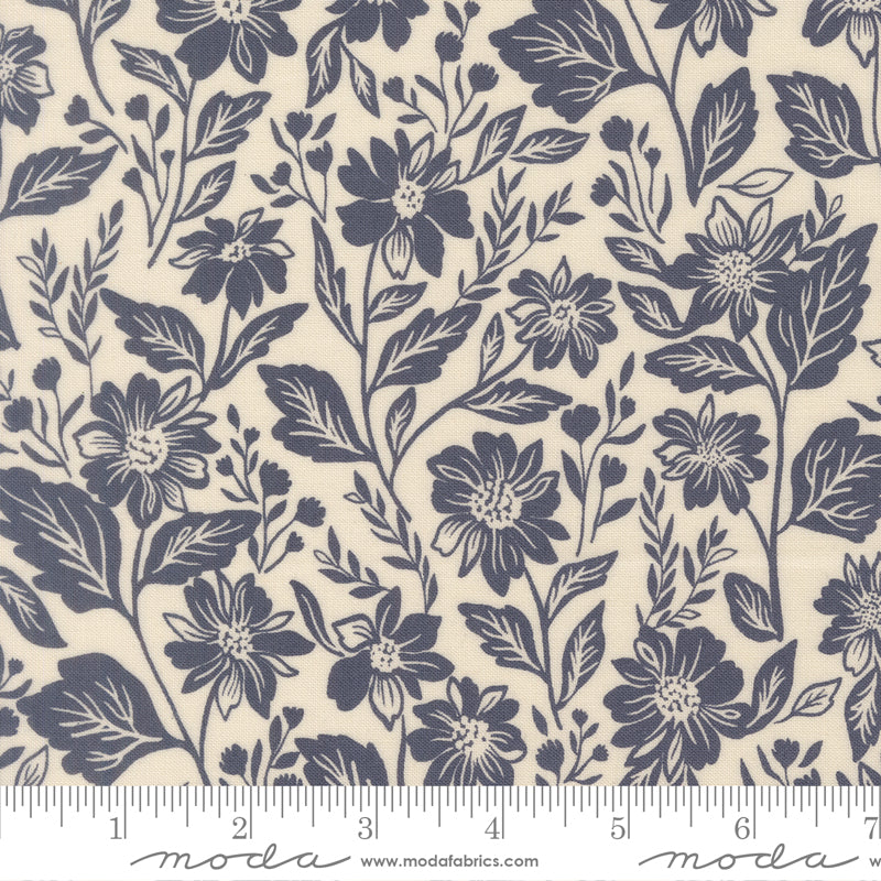 Floral pattern fabric with a ruler at the bottom for scale, featuring navy flowers and leaves on a beige background.