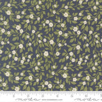 Floral pattern fabric with green leaves and white flowers on a blue background, featuring a ruler for scale.