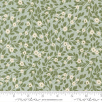 Floral pattern fabric with green leaves and white flowers on a light blue background, featuring a ruler for scale