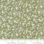 Floral pattern fabric with a ruler at the bottom for scale, featuring light blue leaves and small white flowers on a green background.
