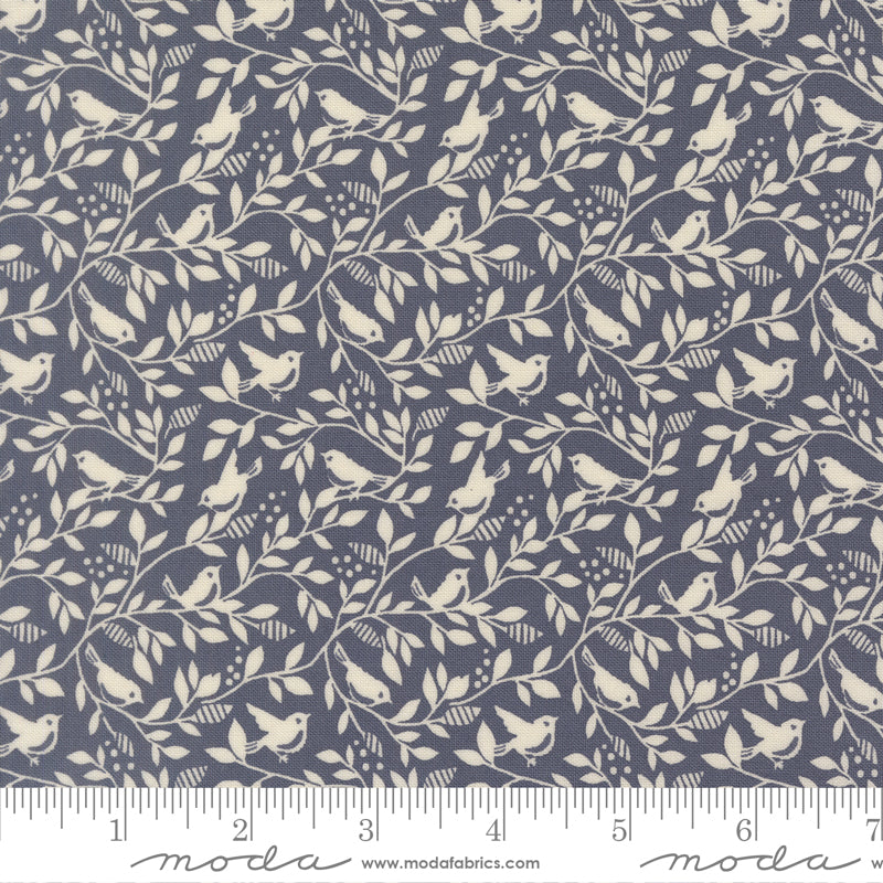 Fabric pattern with birds and leaves on a blue background with a ruler for scale
