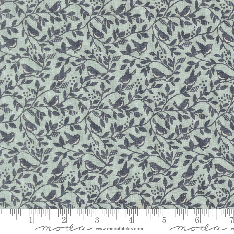 Fabric pattern with birds and leaves on a teal background with a ruler for scale