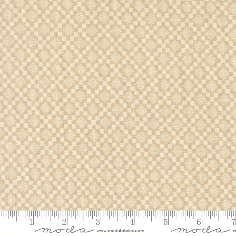 Beige fabric with a subtle diamond pattern with a ruler for scale