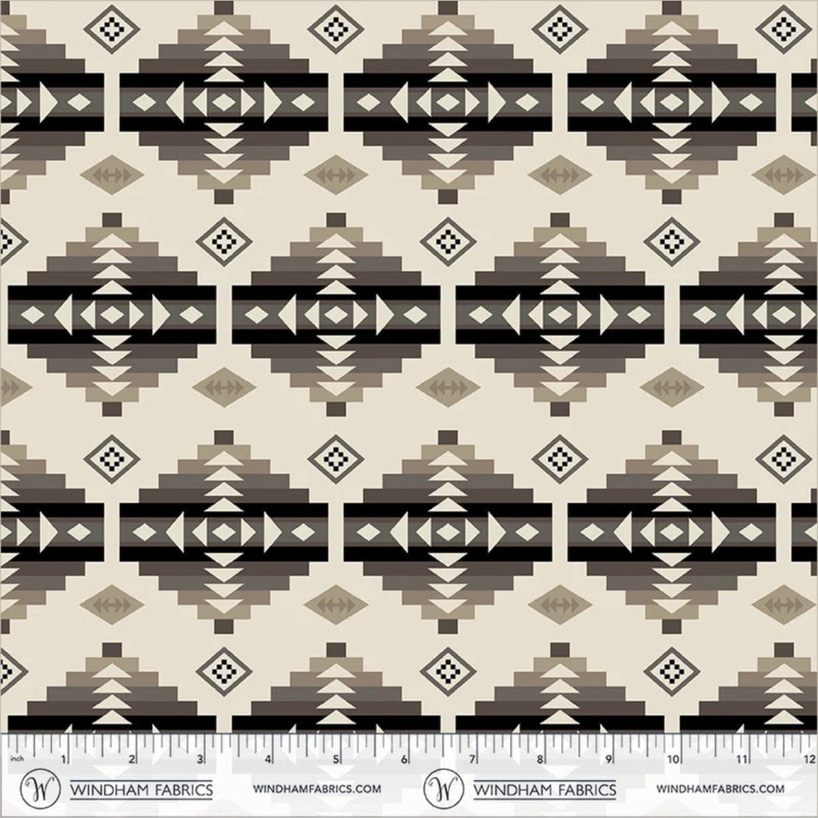 A repeating geometric pattern fabric swatch with Southwestern-style diamond and stepped motifs in beige, brown, taupe, and black, with a ruler and Windham Fabrics branding along the bottom edge.