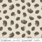 A repeating fabric pattern featuring illustrated pinecones and small pine needles on a warm cream background, with a measuring ruler along the bottom edge showing Windham Fabrics branding.