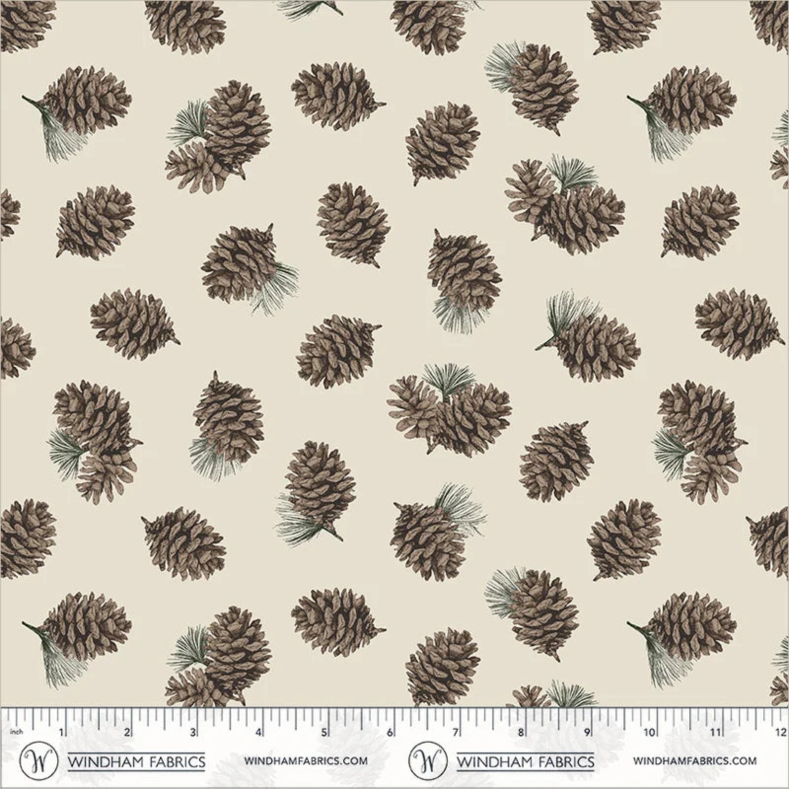 A repeating fabric pattern featuring illustrated pinecones and small pine needles on a warm cream background, with a measuring ruler along the bottom edge showing Windham Fabrics branding.