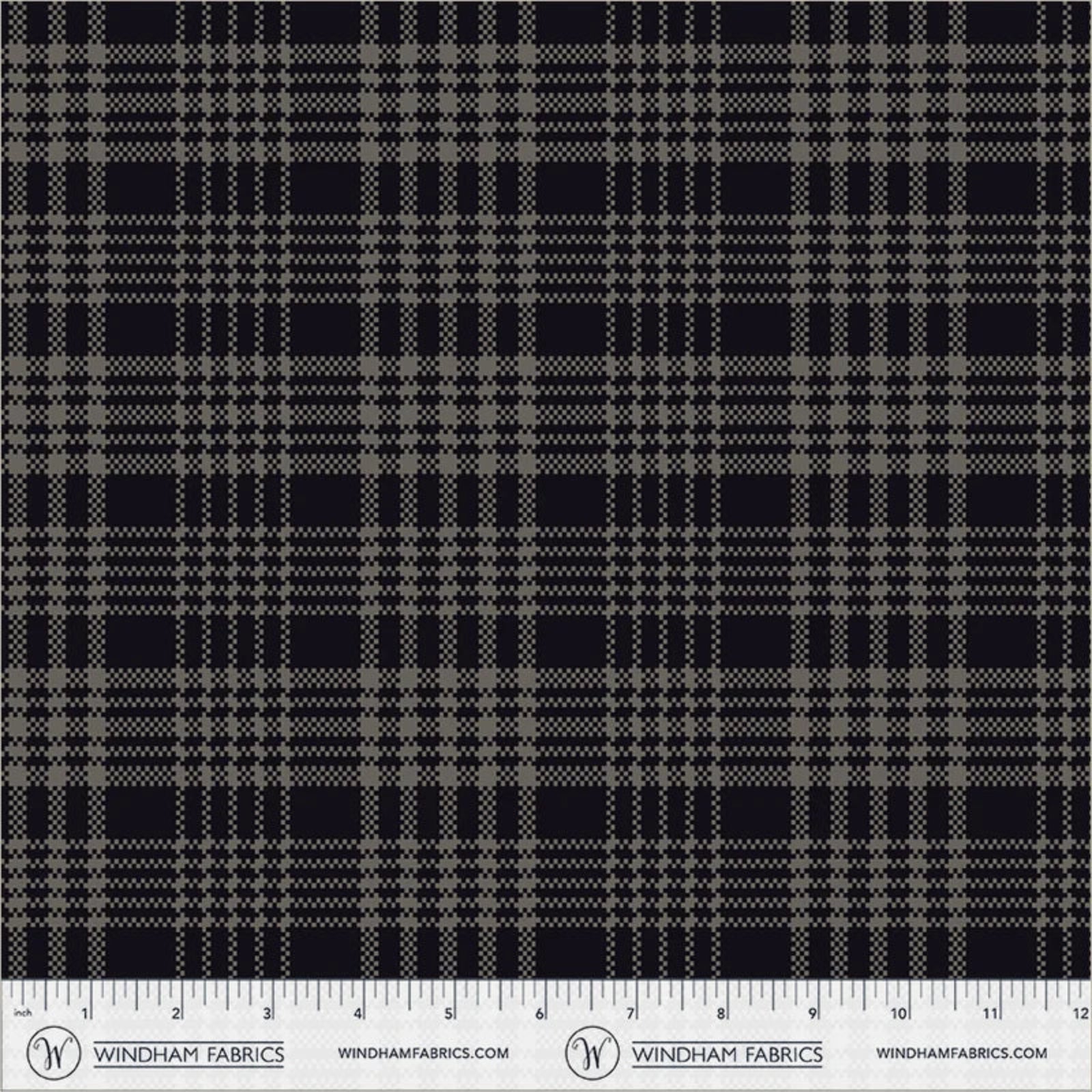 A close-up fabric swatch showing a black and gray plaid pattern with a ruler scale along the bottom edge displaying the brand Windham Fabrics.