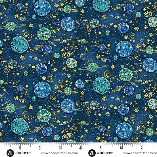 A repeating fabric pattern featuring a space theme with blue and green planets, yellow stars, and small rockets on a dark navy background. A white ruler strip with the brand name 'andover' is visible along the bottom edge.