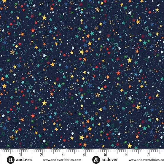 A fabric pattern featuring a dark navy blue background covered in a dense field of small, multi-colored stars in yellow, red, green, and white, with a ruler at the bottom showing scale.