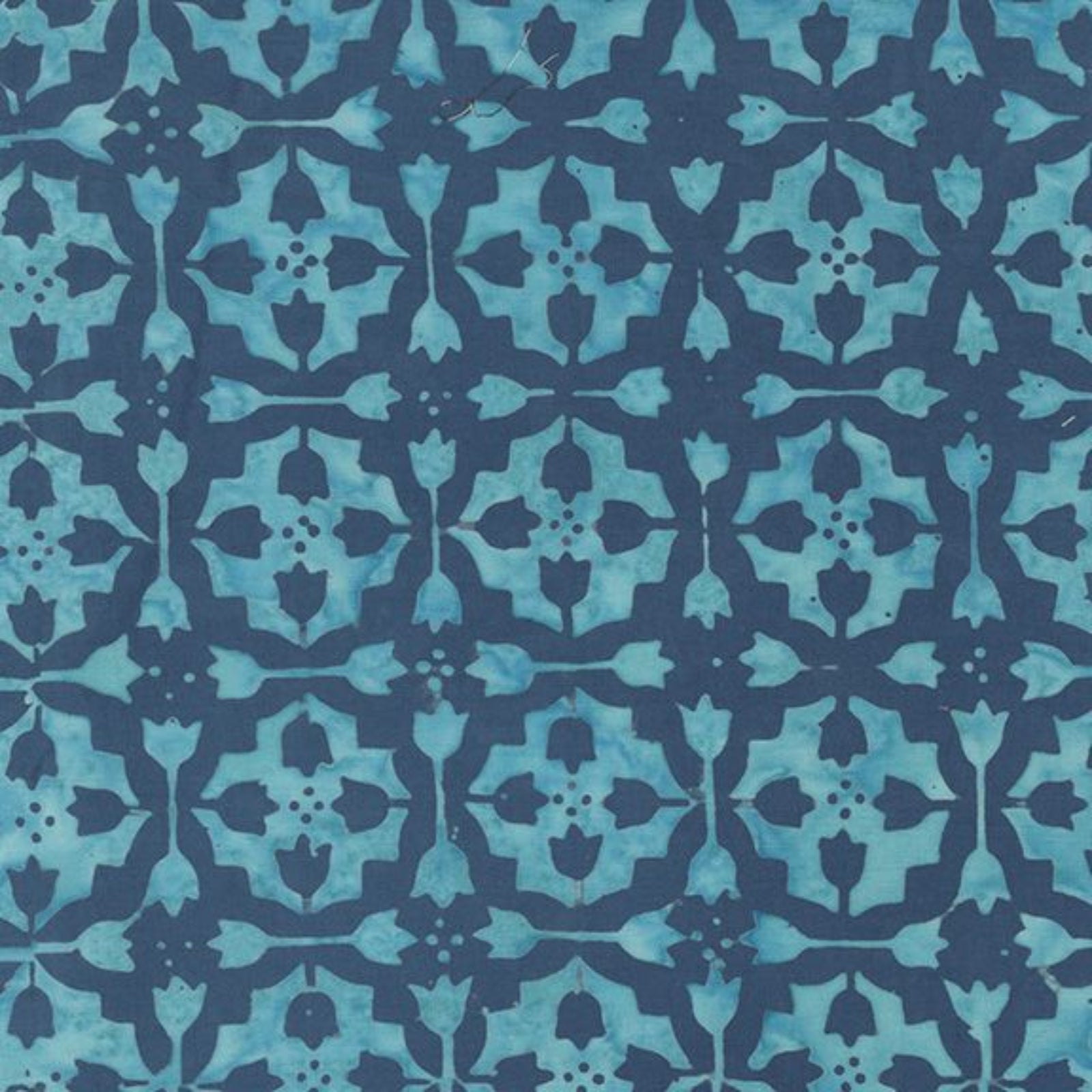 A close-up of a repeating batik-style pattern in turquoise and dark navy blue, showing a detailed geometric and floral motif.