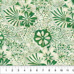 A close-up of a fabric pattern featuring green hand-drawn style floral and leaf motifs on a warm cream background, with a ruler at the bottom showing scale.