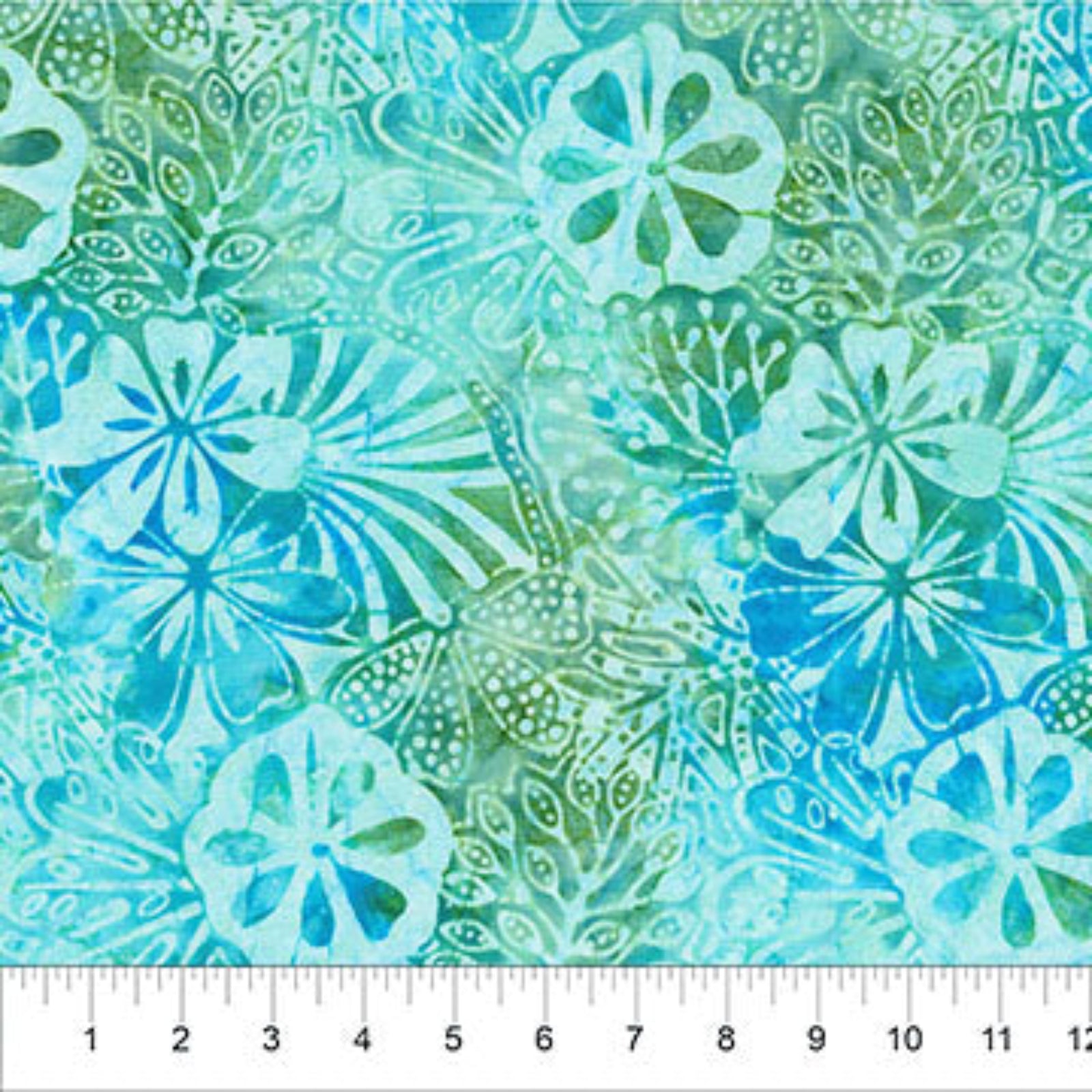 A close-up of a batik fabric pattern featuring tropical hibiscus flowers and leaf motifs in shades of turquoise, teal, and light green, with a white ruler at the bottom showing measurement markings.