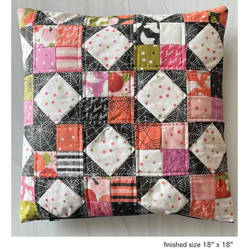 A patchwork quilted square pillow with a Halloween theme, featuring diamond-shaped fabric panels in pink, orange, black, white, and green. The image includes text overlays reading 'Candy Sparkle Pillow' and 'Mini Charm Friendly' along with the brand 'Branch & Blume'.