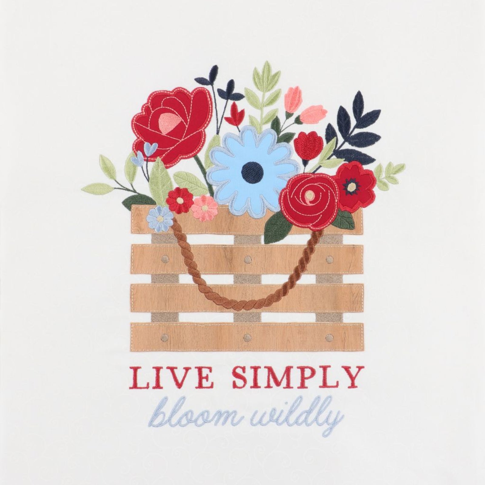 A decorative graphic print featuring a wooden crate filled with colorful flowers and leaves, with the text 'LIVE SIMPLY' in red and 'bloom wildly' in light blue script below, on a plain light background.