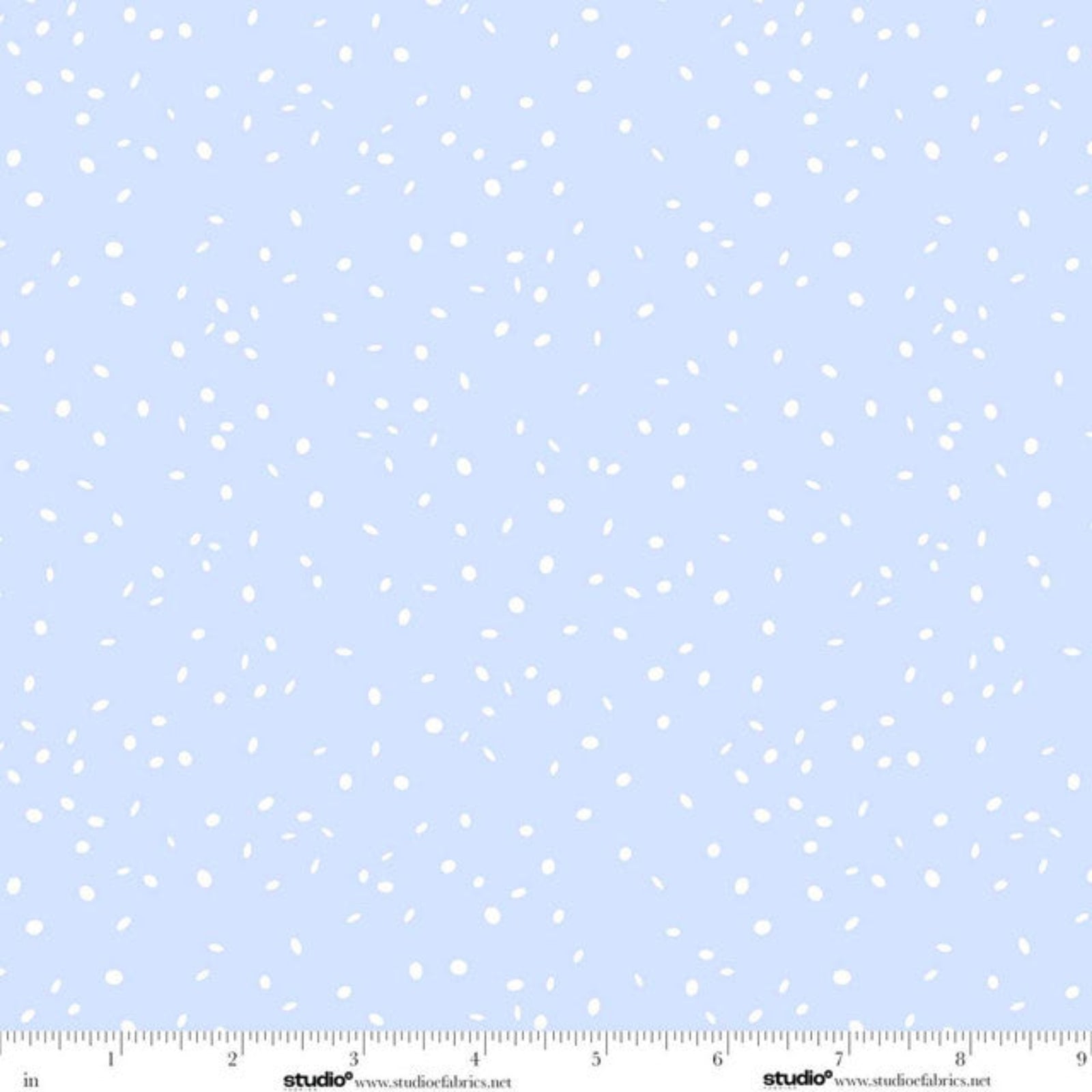Light blue fabric with a scattered white confetti or confuser dot pattern, featuring a white measurement ruler along the bottom edge with studio e branding.