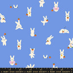 Pattern of white bunnies with carrots and strawberries on a blue background, with a ruler at the bottom.