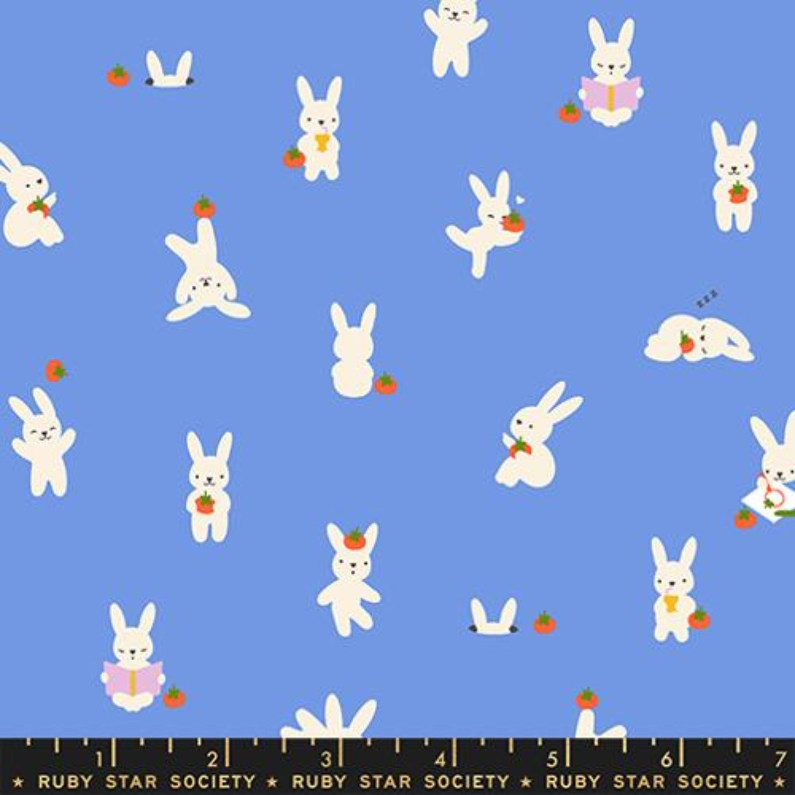 Pattern of white bunnies with carrots and strawberries on a blue background, with a ruler at the bottom.