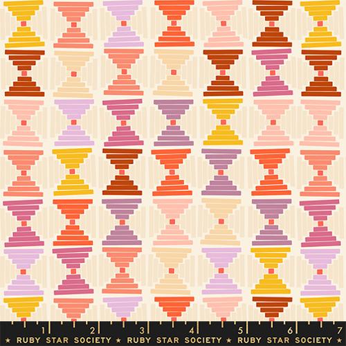 Colorful geometric pattern fabric with a ruler at the bottom, featuring colors like pink, orange, yellow, and purple on a beige background. Brand 'Ruby Star Society' is visible.