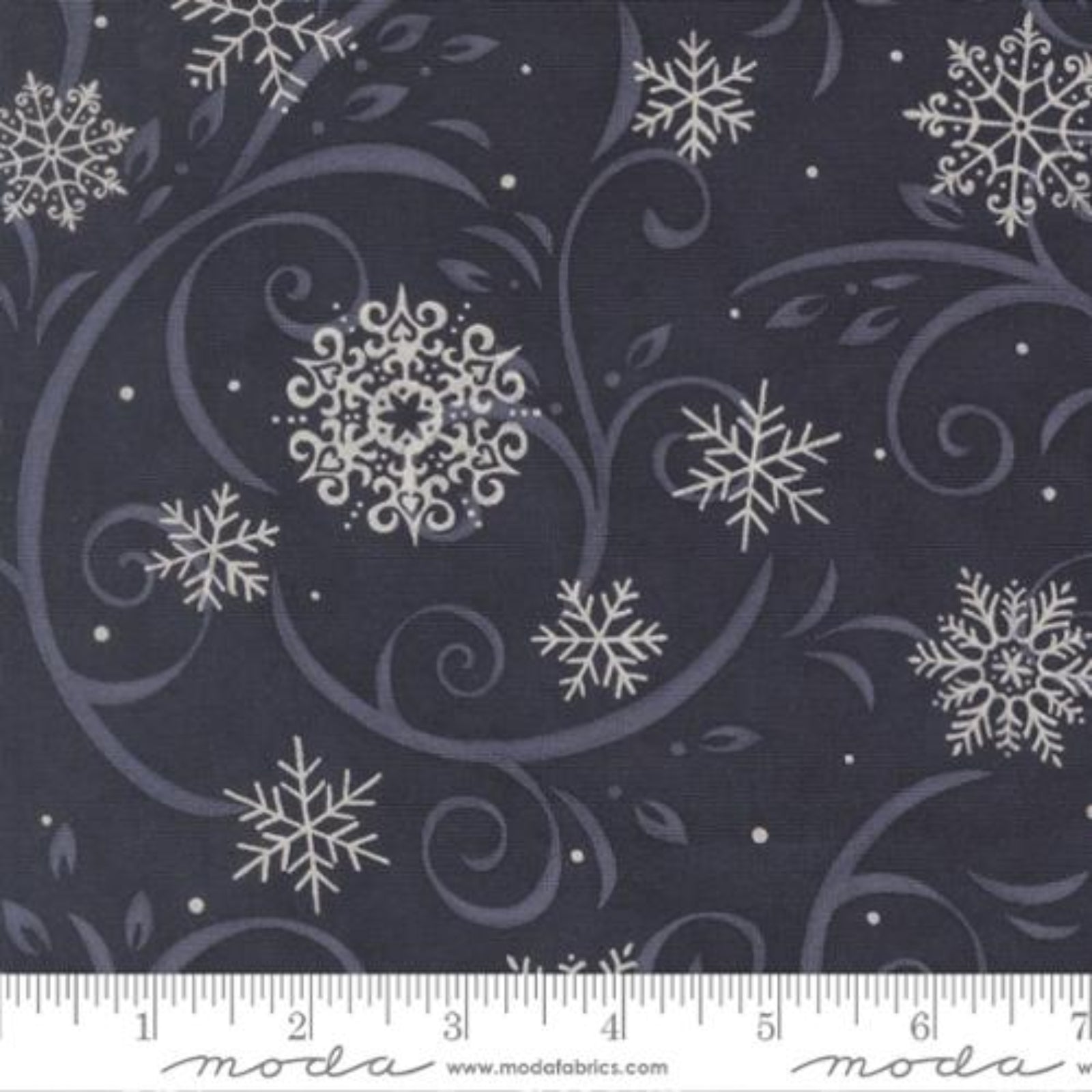Fabric with snowflake pattern on a dark background, featuring a ruler for scale.