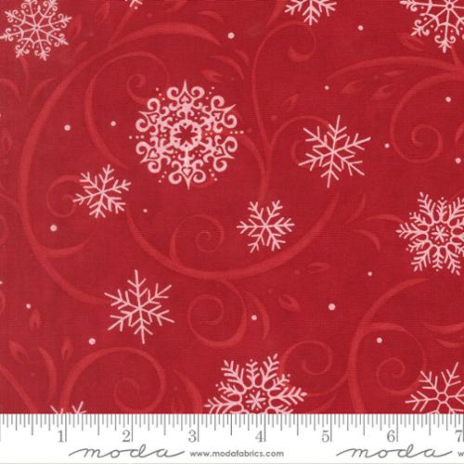 Red fabric with white snowflakes and swirls, featuring Moda label.