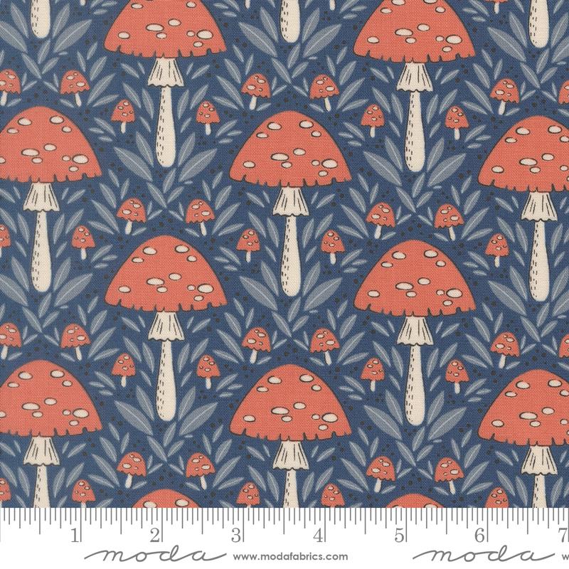 Mushroom pattern fabric with a ruler at the bottom for scale, featuring red mushrooms on a blue background.