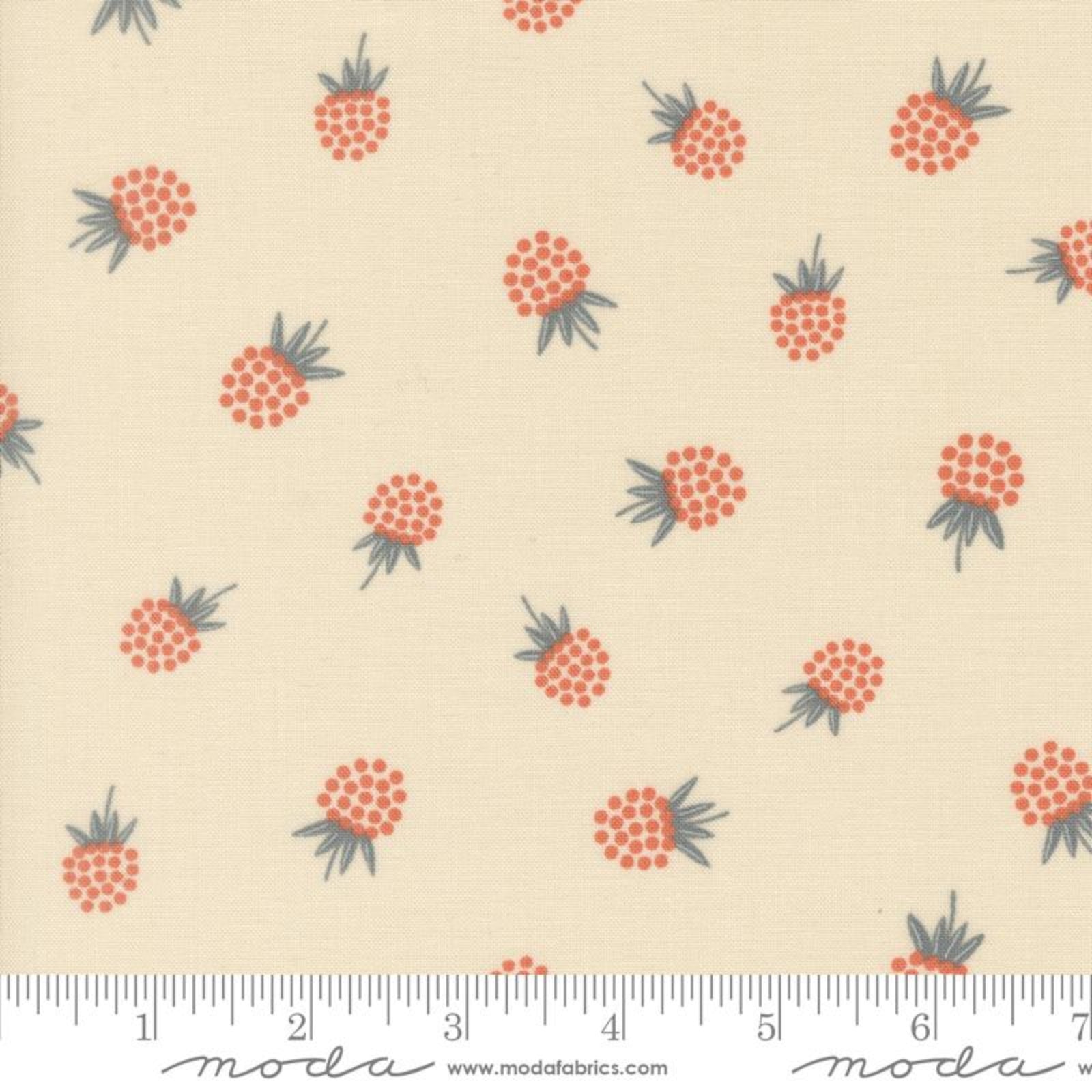 A fabric pattern featuring small orange-red pineapples with dark green tops on a warm cream background, with a measuring ruler along the bottom edge showing Moda Fabrics branding.