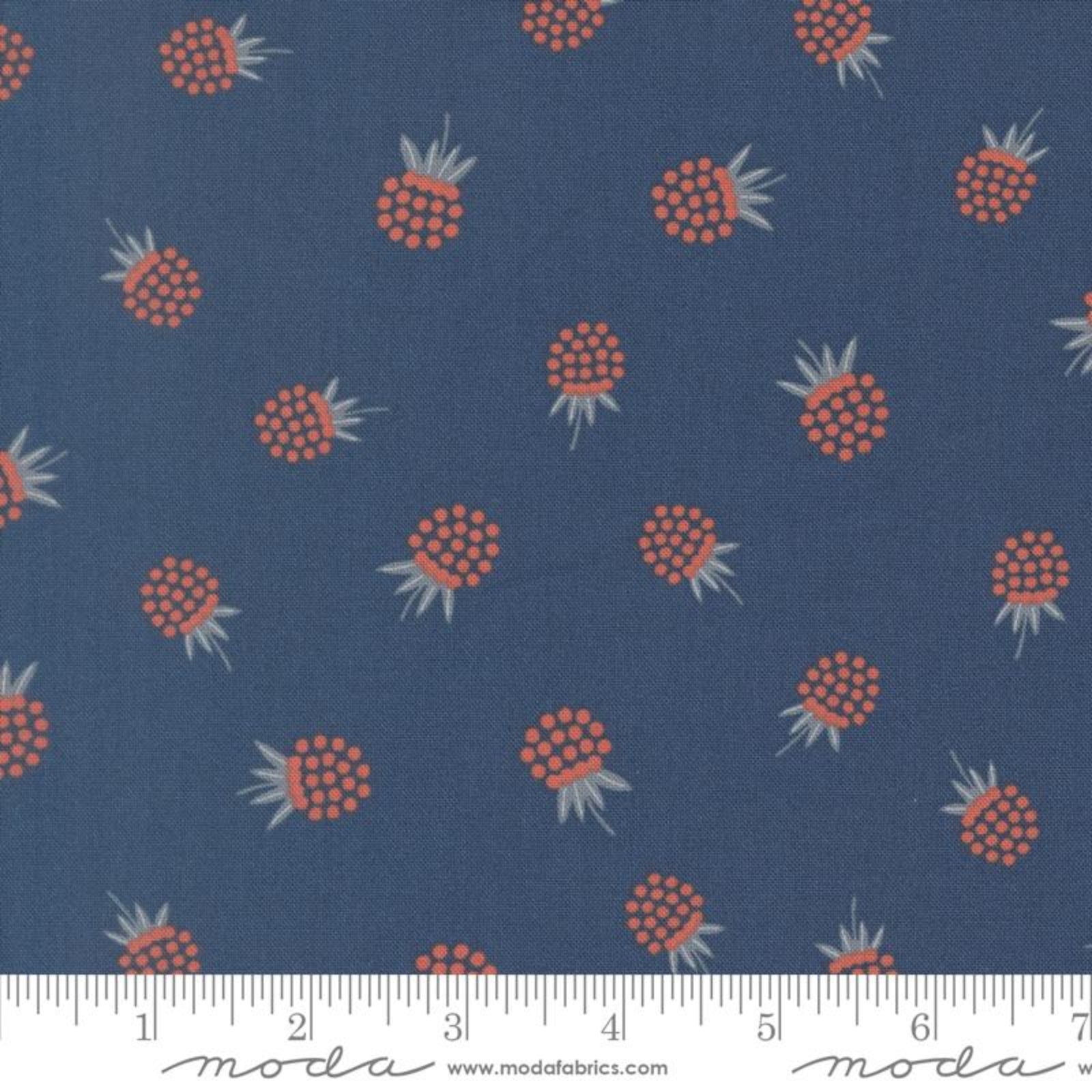 A close-up of a fabric pattern featuring orange-brown berries with light green tops on a dark blue background, with a white ruler at the bottom showing scale. The brand name 'modafabrics' is visible on the ruler.