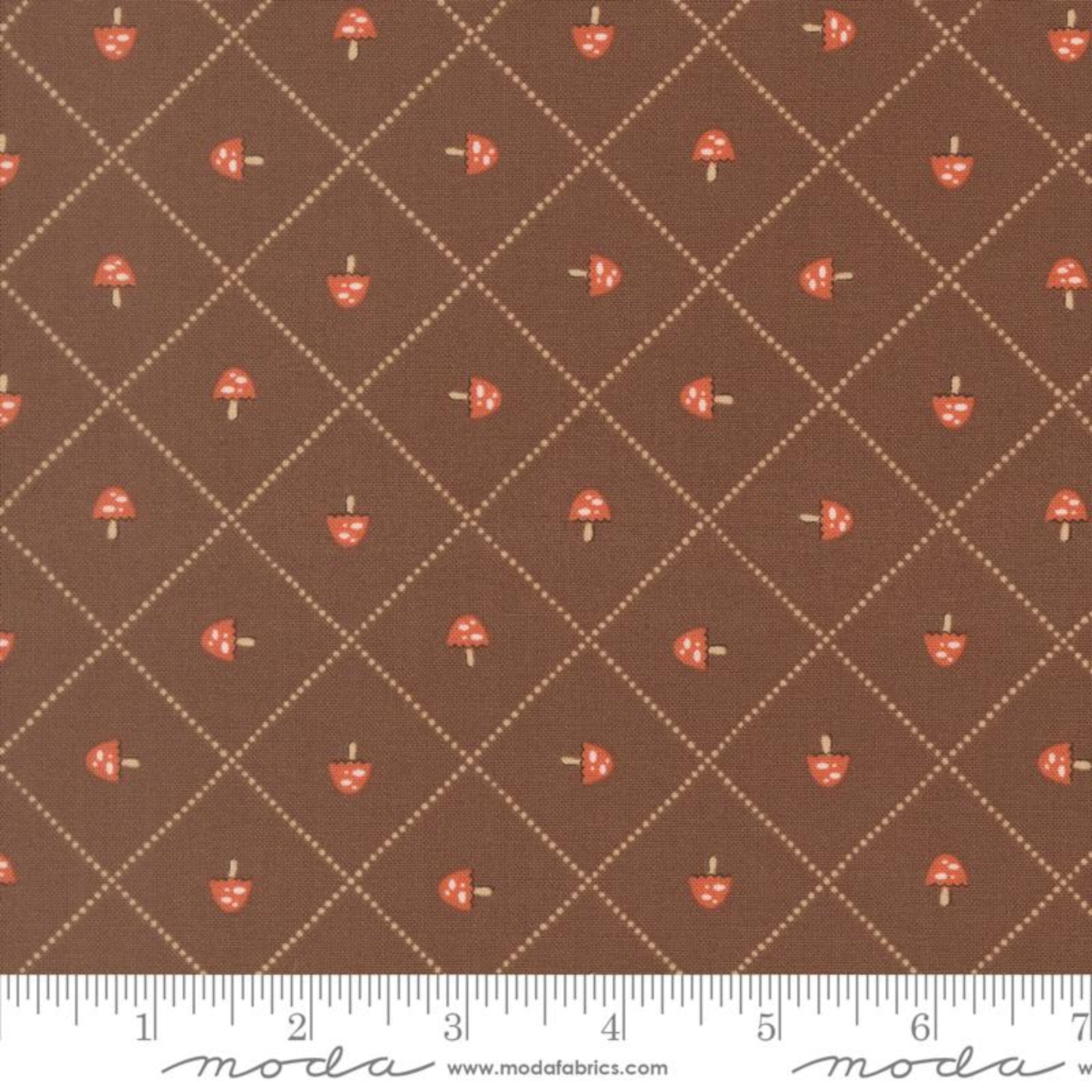 Brown fabric with a repeating pattern of small red-and-white mushrooms and a beige dotted diamond grid, shown with a ruler along the bottom edge. The brand name Modafabrics is visible at the bottom.