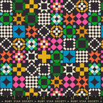 Colorful geometric quilt pattern with a ruler at the bottom on a black background