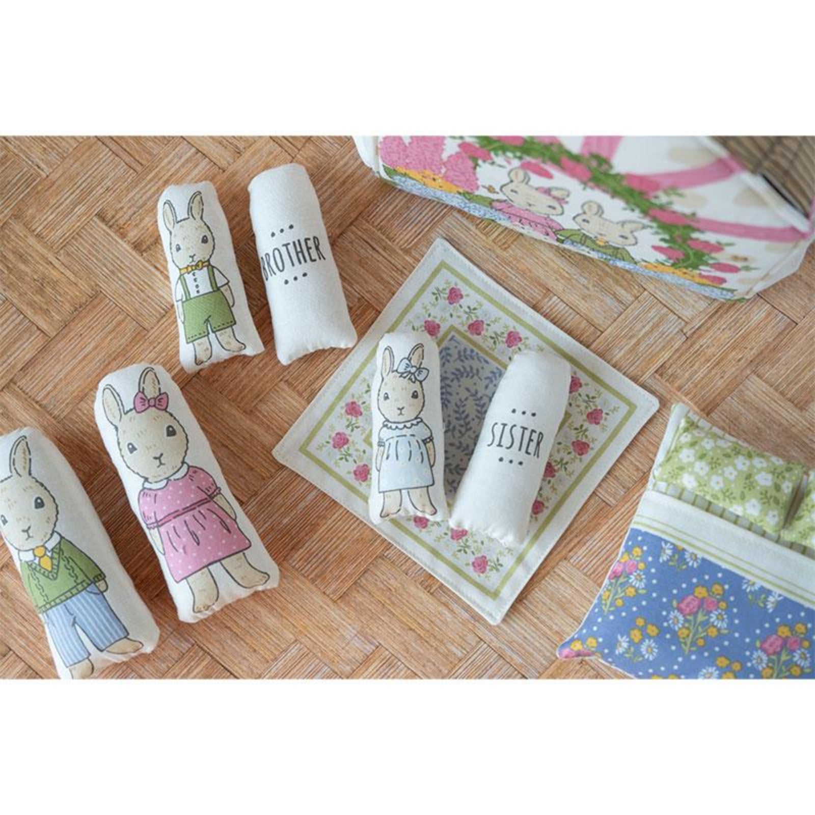 Decorative pillows with rabbit illustrations and text on a wooden floor.