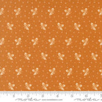 Orange fabric with a repeating cream butterfly and dot pattern, shown flat with a ruler along the bottom edge for scale. The Modas Fabrics watermark is visible at the bottom.