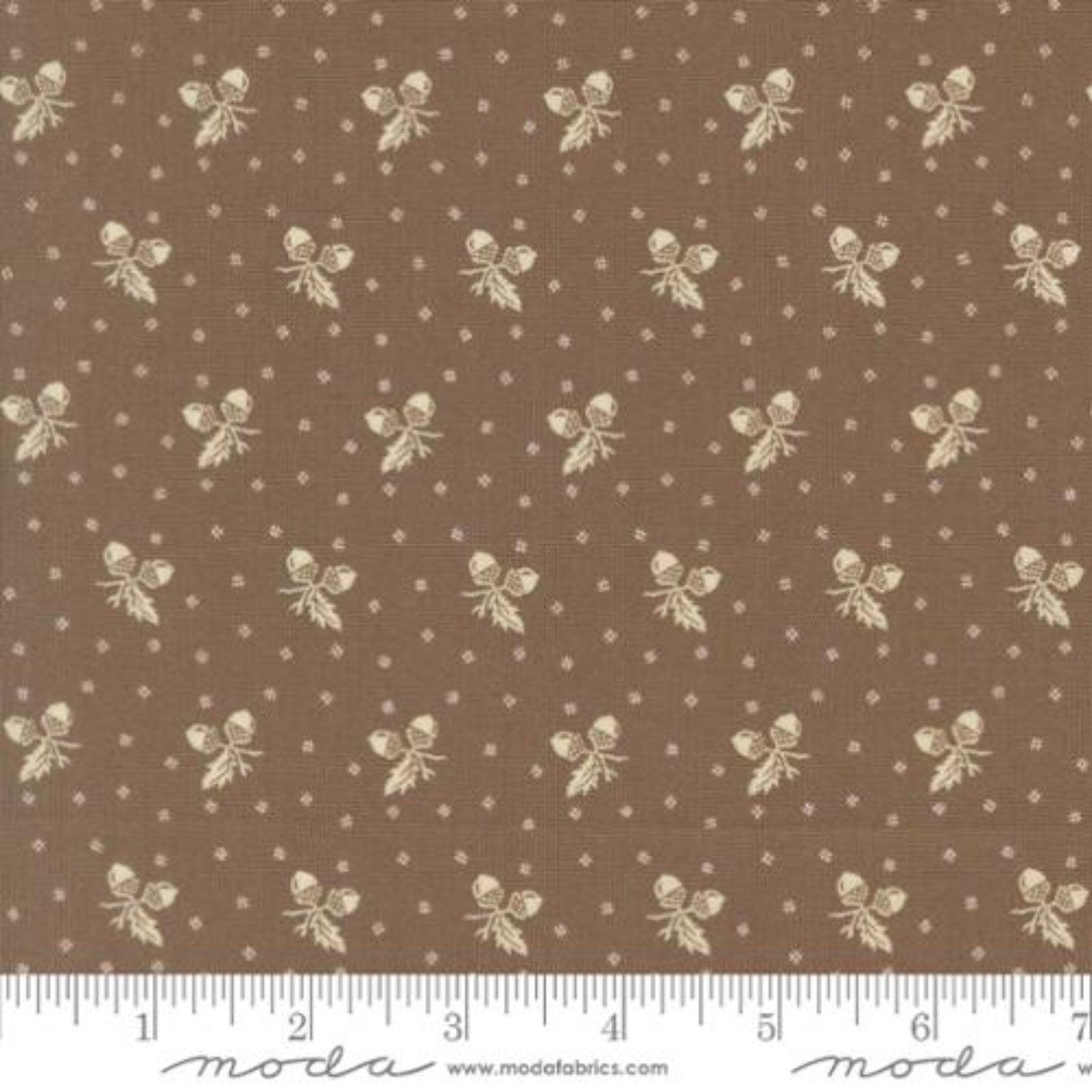 Brown fabric with a repeating pattern of cream bows, small bows, and tiny dots, shown with a white ruler along the bottom edge.