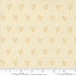 A close-up of a fabric pattern featuring small tan butterfly motifs and tiny gold dots on a warm cream background, with a ruler along the bottom edge showing measurements.