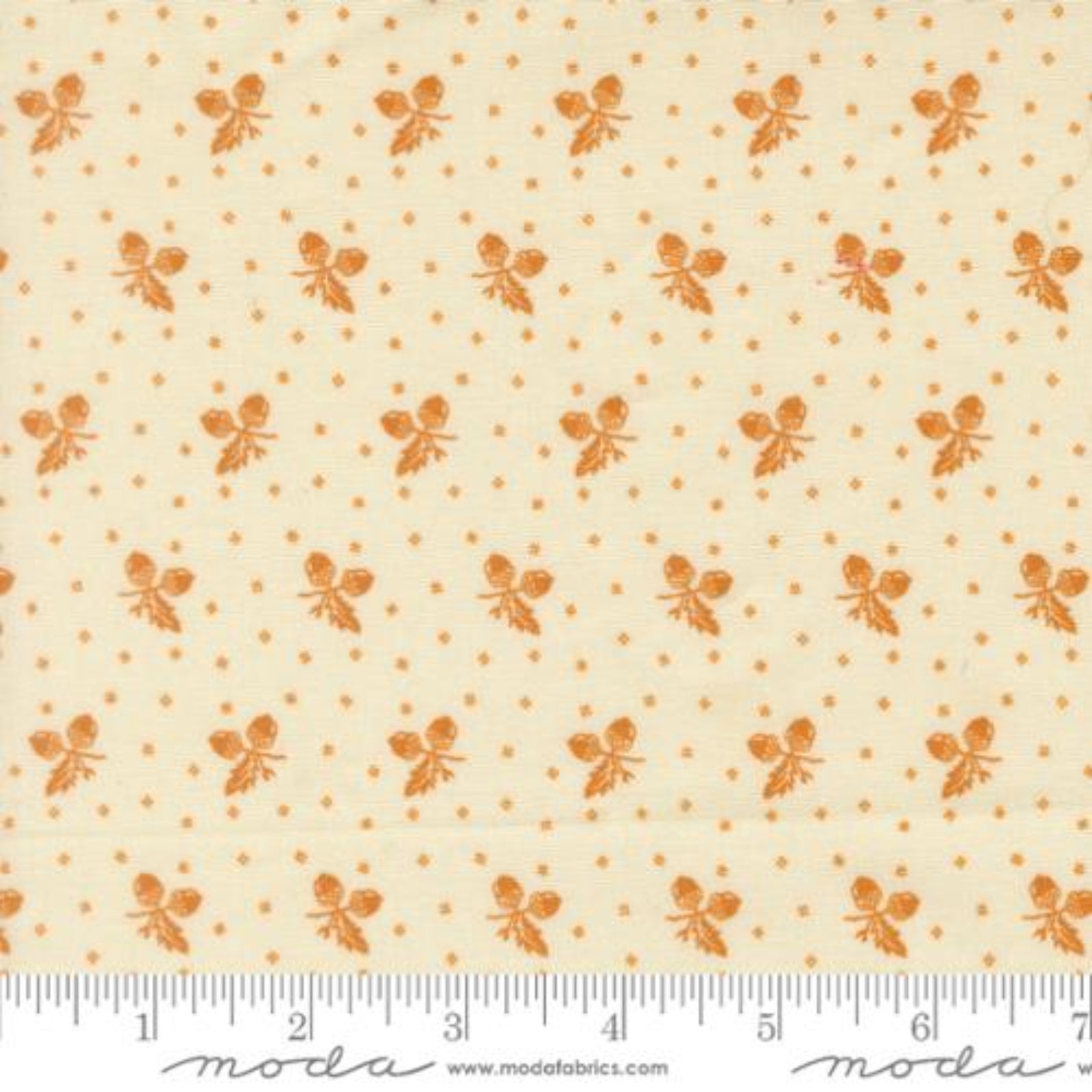 A close-up of a fabric pattern featuring small orange butterfly motifs and tiny orange dots on a warm cream background, with a ruler along the bottom edge and a Modas fabric watermark.