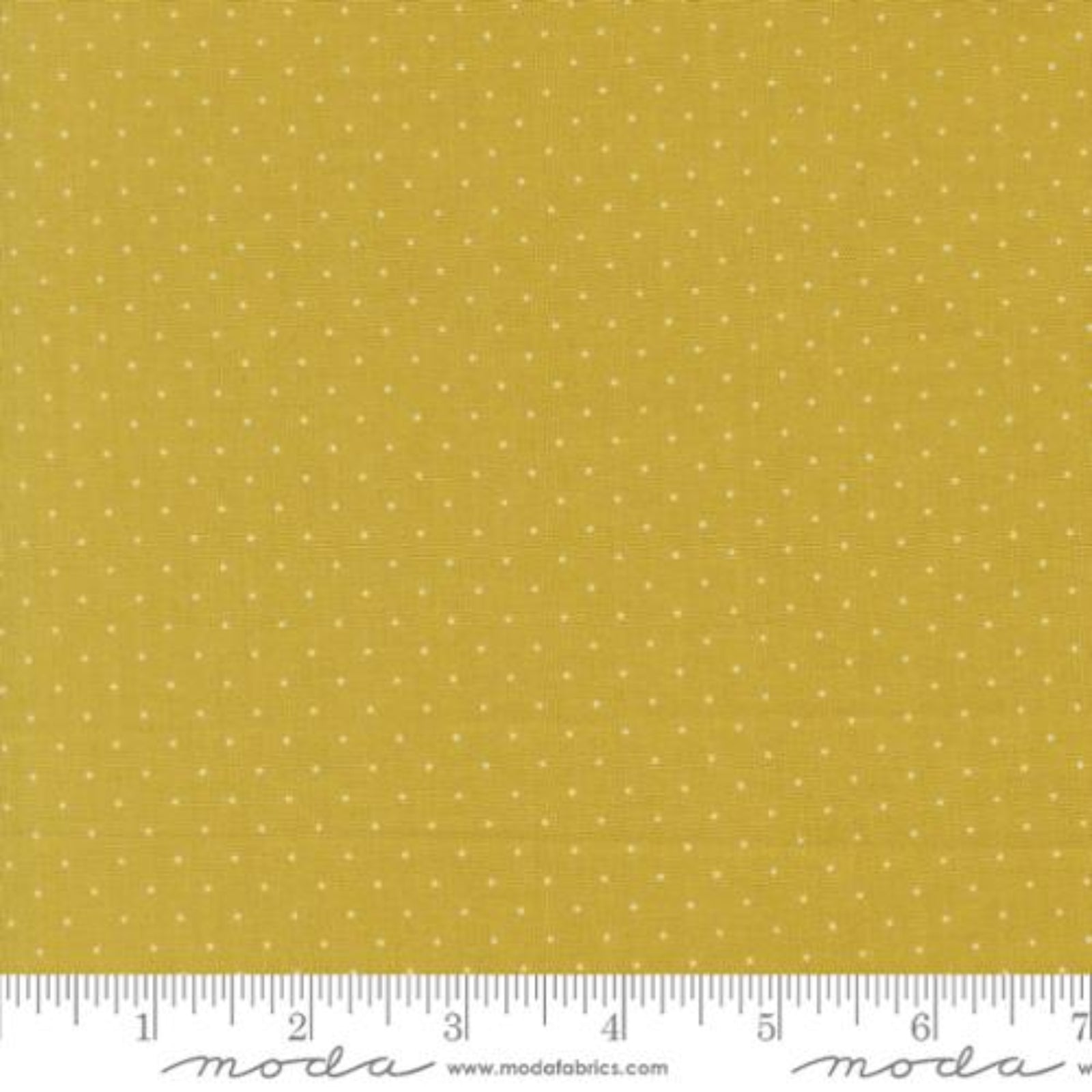 Yellow fabric with a small white polka dot pattern and a white ruler along the bottom edge showing measurements.