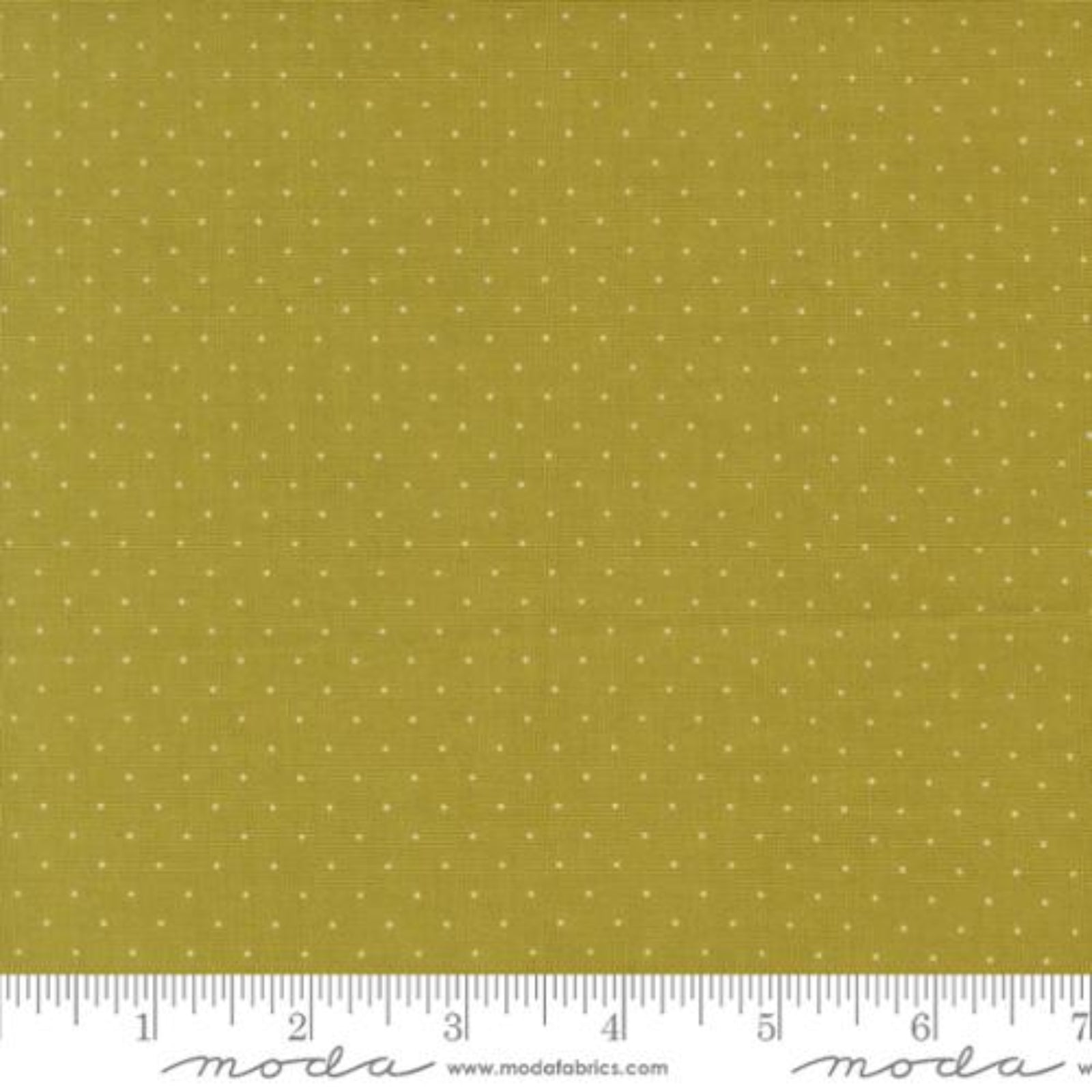 A close-up of a fabric swatch showing a mustard yellow background with a small white polka dot pattern, with a ruler and Modla branding along the bottom edge.