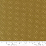 A close-up of a fabric pattern featuring small white polka dots on a warm mustard yellow background, with a white ruler along the bottom edge showing scale and Modas Fabrics branding.