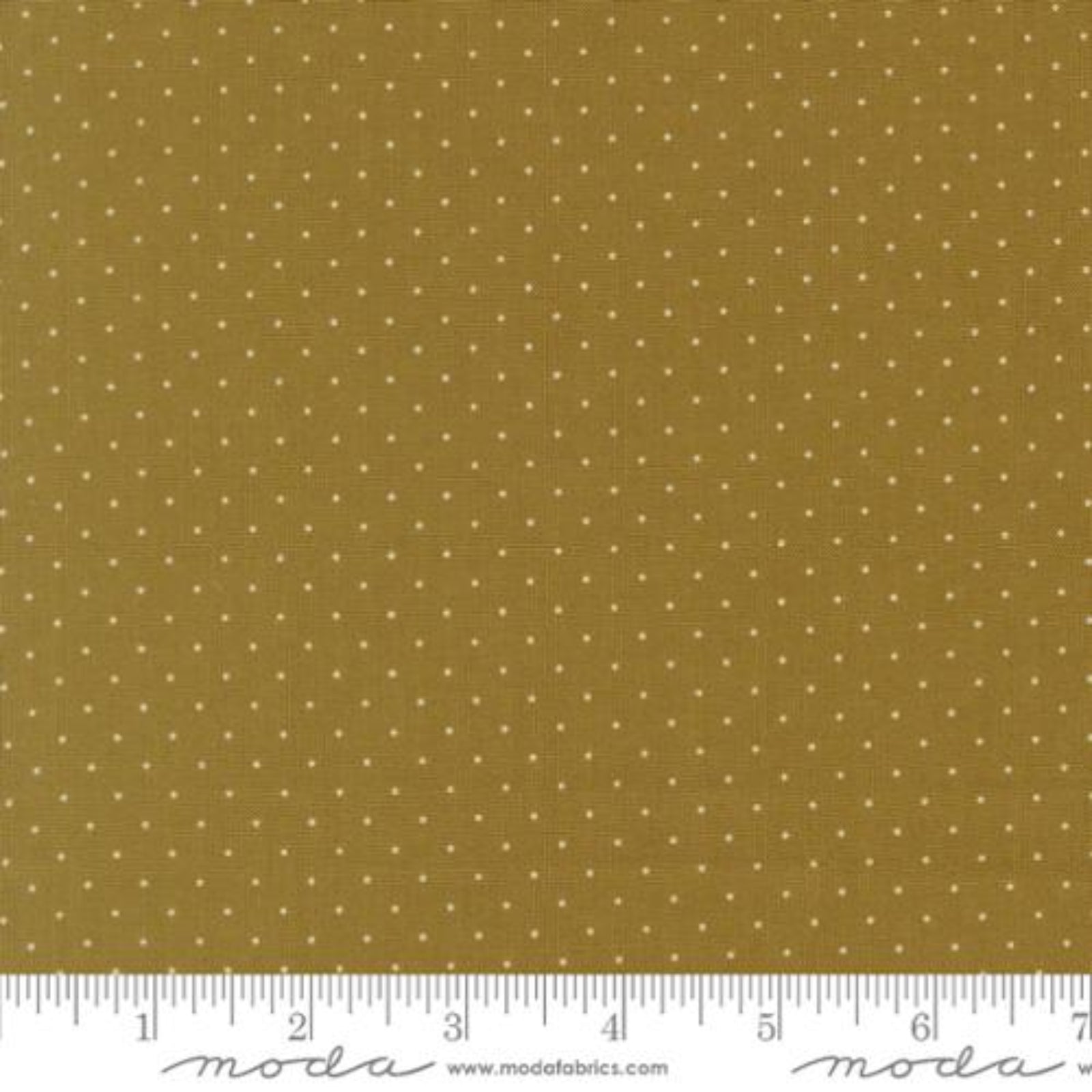 A close-up of a fabric pattern featuring small white polka dots on a warm mustard yellow background, with a white ruler along the bottom edge showing scale and Modas Fabrics branding.