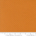 Orange fabric with a small white polka dot pattern, shown with a measuring ruler at the bottom to indicate scale. The brand name 'Moda Fabrics' is visible on the ruler.